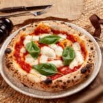 Pizza margherita z pieca opalanego drewnem z bazylią i mozzarellą