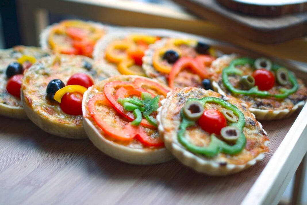 Zbliżenie na domowe mini pizze z kolorowymi warzywami na przekąskę Zbliżenie na domowe mini pizze z kolorowymi warzywami na przekąskę